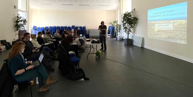 Group of seated people watching a presentation on a screen